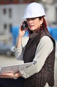 stock photo of communication  - Female site manager using radio to communicate - JPG 