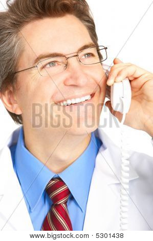 Picture or Photo of Smiling medical doctor calling by phone. Over white background