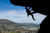 picture of rocks  - Rock climbing on overhang with town in background - JPG 