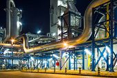 stock photo of industrial  - pumps and piping system inside of industrial plant at night - JPG 