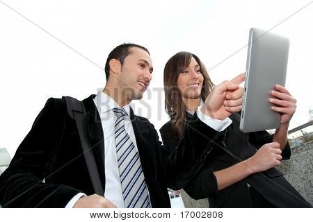 Picture or Photo of Business people meeting outside with electronic tablet