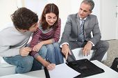 picture of agent  - Young couple signing renting contract with real estate agent - JPG 
