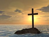 stock photo of religion  - Concept or conceptual dark christian cross standing on a rock in the sea or ocean over a beautiful sky at sunset as a metaphor for faith - JPG 