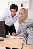 stock photo of business people  - Younger and older men looking at a computer - JPG 