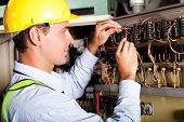 stock photo of industrial  - male electrician testing industrial machine - JPG 