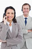 stock photo of center  - Smiling call center agents with headsets on and arms folded against a white background - JPG 