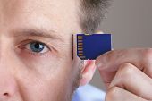 stock photo of insert  - Inserting SD memory card into slot in human head concept for memory upgrade - JPG 