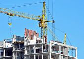 image of construction  - Building crane and building under construction against blue sky - JPG 