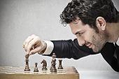 picture of business concept  - young business man playing chess - JPG 