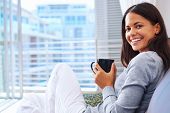 pic of home  - Woman enjoys fresh coffee relaxing at home on the sofa couch - JPG 