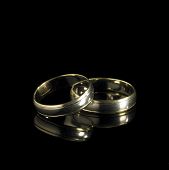 picture of black  - studio photography of 2 golden wedding rings in black reflective back - JPG 