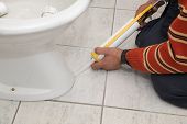 foto of silicon  - Plumber fixing bidet in a washroom with silicone cartridge - JPG 