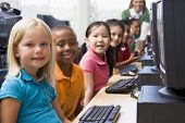 pic of computer  - Children at computer terminals with teacher in background  - JPG 