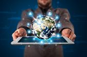 stock photo of globe  - Young businessman presenting 3d earth globe in tablet  - JPG 