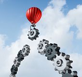 stock photo of bridge  - Business bridge building with a red hot air balloon lifting a gear up to the sky to construct and complete a bridged chain of cogs connected together as a result of strategy and planning for success - JPG 