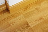 picture of construction  - Close up showing some laminate flooring and mdf imitation wood skirting boards in newly constructed house - JPG 