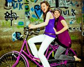 stock photo of laughter  - two girls having fun on a bicycle - JPG 