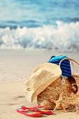 stock photo of beach  - Closeup of summer beach bag with items on sandy beach - JPG 