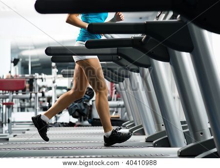 Picture or Photo of Woman running on a treadmill in a fitness club, sport in the fitness club