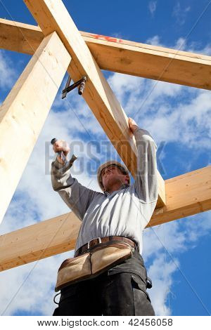 Picture or Photo of Real builder  at work with wooden  roof construction