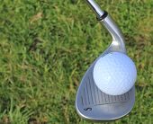 pic of golf  - A golf ball balanced on a sandwedge golf club - JPG 