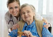 stock photo of home  - Senior woman is visited by her doctor or caregiver - JPG 