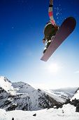 foto of blue sky  - Snowboarder jumping through air with deep blue sky in background - JPG 