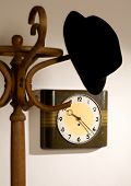 image of tick tock  - hat on a hanger with a clock in the background - JPG 