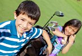 picture of golf  - Kids playing golf and holding a bag at the course - JPG 