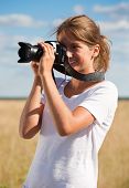 foto of  photo  - Young girl taking photo with camera against field - JPG 