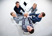 picture of business people  - Above view of business people with their hands on top of each other looking at camera - JPG 