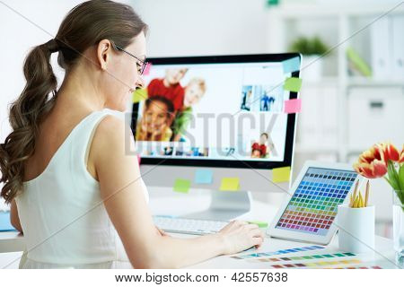Picture or Photo of Portrait of pretty female designer working with colors at home