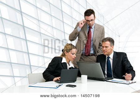 Picture or Photo of Group of business people analyzing and discussing during a working meeting in a modern office
