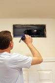 pic of interior  - Adult male shining a flashlight into an air duct return vent to check for any need of cleaning dust or any other maintenance.
** Note: Shallow depth of field - JPG 