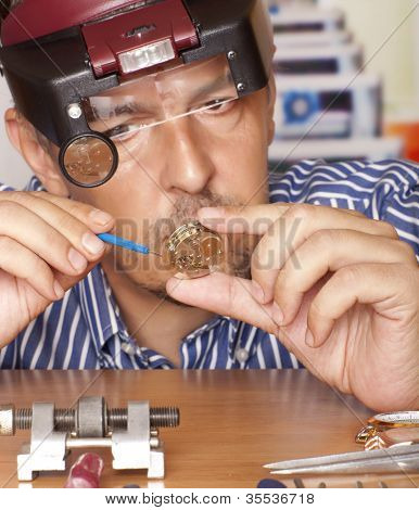 Picture or Photo of Watch repair craftsman repairing watch. Focus on watch