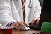 picture of medical doctors  - Doctor using a laptop computer to prepare an online prescription - JPG 