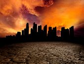 stock photo of earth  - City overlooking desolate desert landscape with cracked earth - JPG 