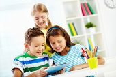 pic of youngster  - Portrait of happy classmates at workplace using digital tablet - JPG 