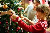 stock photo of holidays  - Portrait of happy girl decorating Christmas tree - JPG 