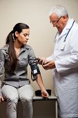 stock photo of pressure  - Senior male doctor taking young woman - JPG 