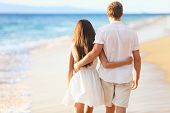 picture of beach  - Vacation couple walking on beach together in love holding around each other - JPG 