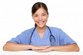 stock photo of medical doctors  - Nurse leaning on sign edge smiling happy - JPG 