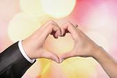 image of religion  - Hands bride and groom in a heart shape on a colored background defocused - JPG 