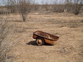 A child's wagon abandoned and left to rust in the Arizona desert.