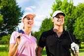 picture of golf  - Young sportive couple playing golf on a golf course - JPG 