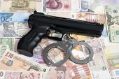 foto of currency  - Currency from world with handcuffs and handgun - JPG 