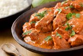 picture of restaurant  - A bowl of creamy butter chicken curry with basmati rice and limes - JPG 