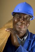 foto of construction worker  - Senior South African or American plumber carpenter or builder with wooden planks - JPG 