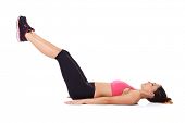 picture of muscle  - Woman doing leg lifts to strengthen her abdominal muscles while lying on the floor working out - JPG 