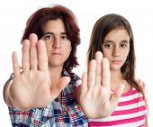 stock photo of teenager  - Young latin woman and a teenage girl signaling to stop with their hands extended isolated on white  - JPG 